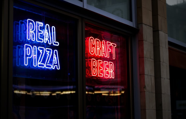 sign saying 'Real Pizza' and 'Craft Beer' on window of restaurant